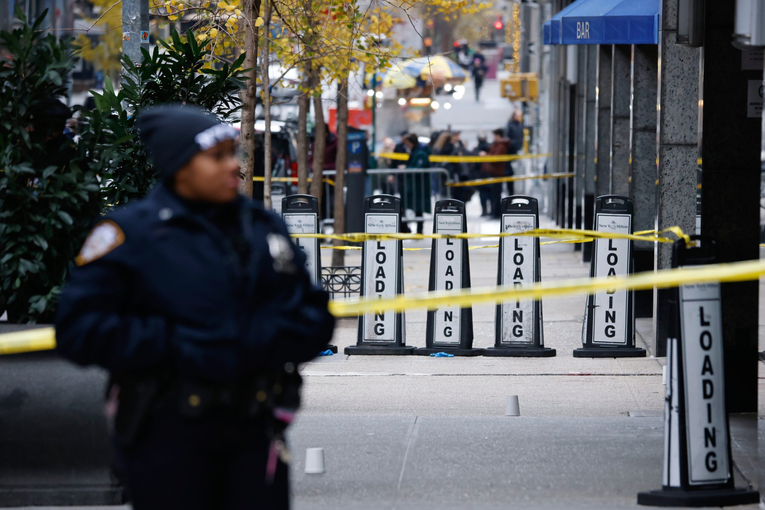 A New York police officer stands outside the Hilton hotel in Midtown Manhattan where Brian Thompson, the CEO of UnitedHealthcare, was fatally shot